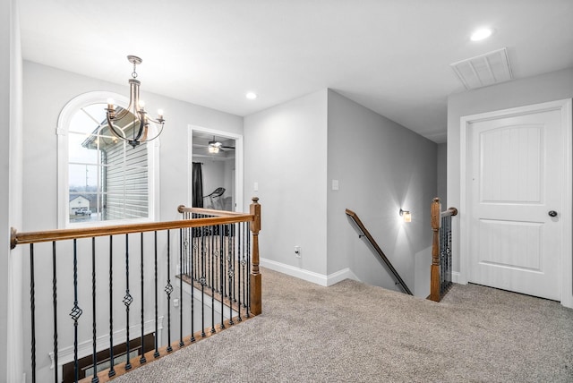 corridor with carpet floors and a notable chandelier