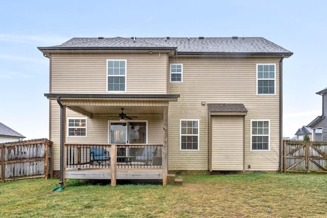 back of property featuring a wooden deck, a yard, and ceiling fan