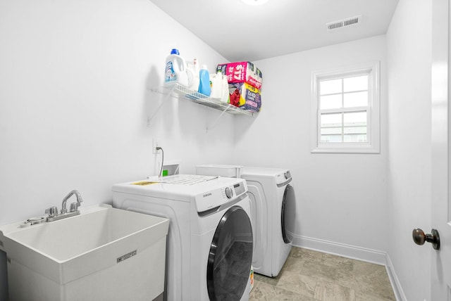 clothes washing area featuring independent washer and dryer and sink