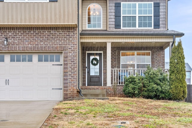 view of exterior entry with a garage and a porch