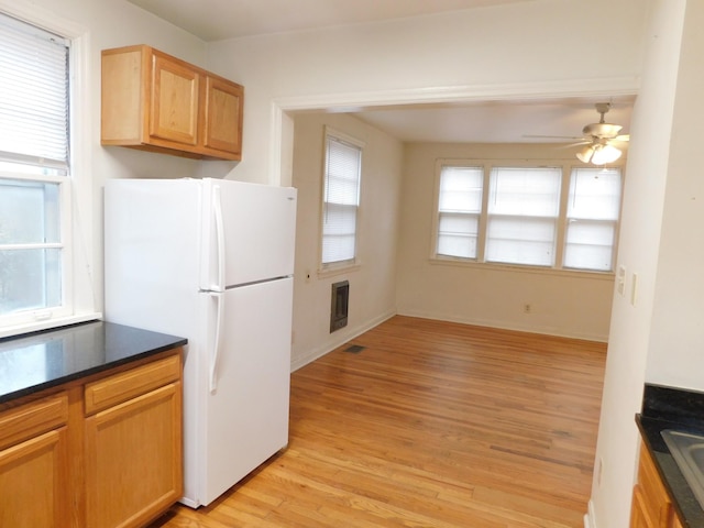 kitchen with sink, heating unit, light wood-type flooring, white fridge, and ceiling fan