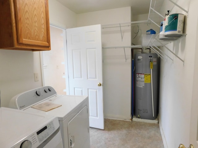 laundry area featuring water heater, washing machine and dryer, and cabinets