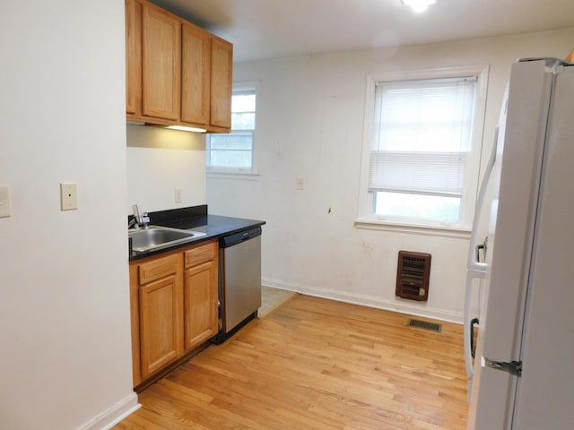 kitchen with heating unit, sink, white fridge, stainless steel dishwasher, and light wood-type flooring