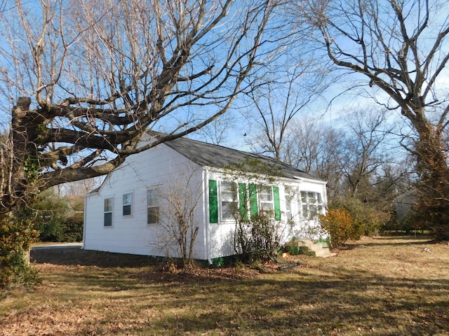 view of side of home with a yard