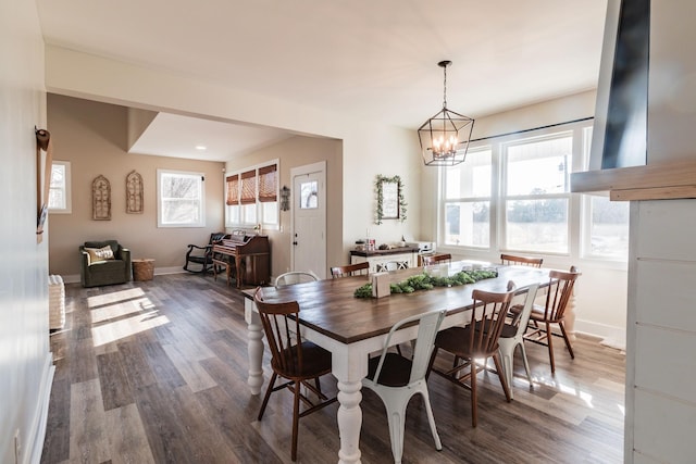 dining area featuring a notable chandelier and dark hardwood / wood-style floors