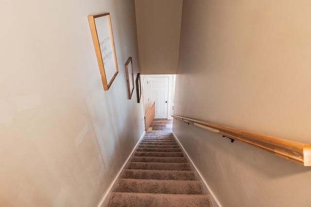 stairs featuring a high ceiling and carpet