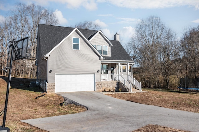 view of front facade with a trampoline, a garage, and covered porch