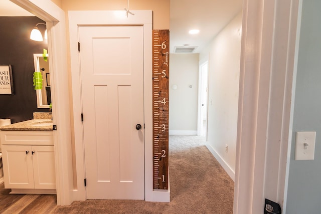 hallway featuring light colored carpet