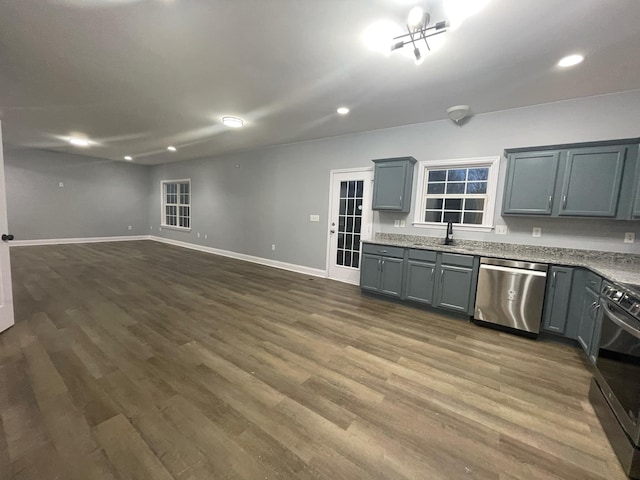 kitchen with gray cabinets, dark hardwood / wood-style floors, sink, stainless steel dishwasher, and range