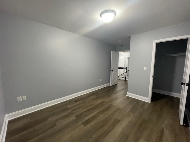 unfurnished bedroom with dark hardwood / wood-style floors and a closet