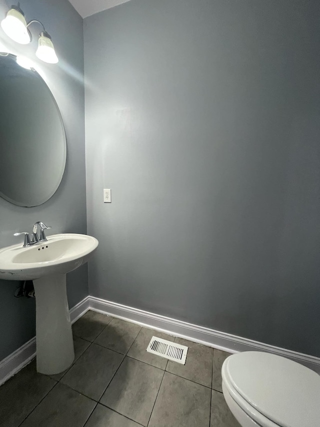 bathroom featuring sink, toilet, and tile patterned flooring