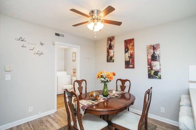 dining space featuring washer / clothes dryer, ceiling fan, and light wood-type flooring