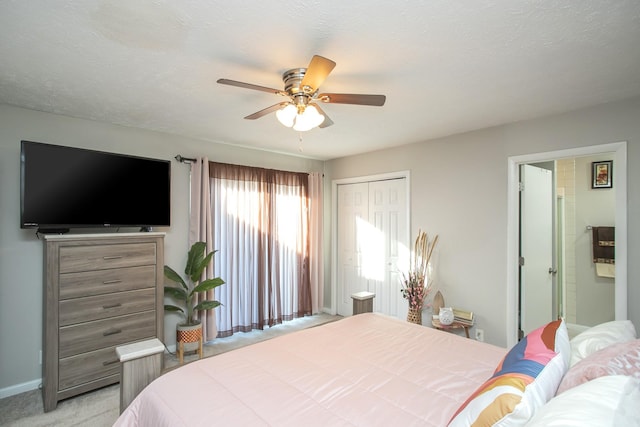 bedroom featuring ensuite bathroom, light carpet, a textured ceiling, and a closet