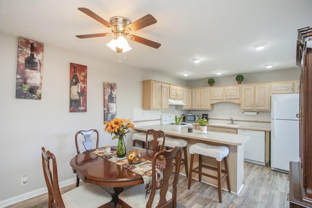 dining space featuring sink, ceiling fan, and light wood-type flooring