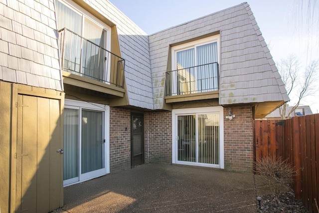 back of house featuring a balcony and a patio area