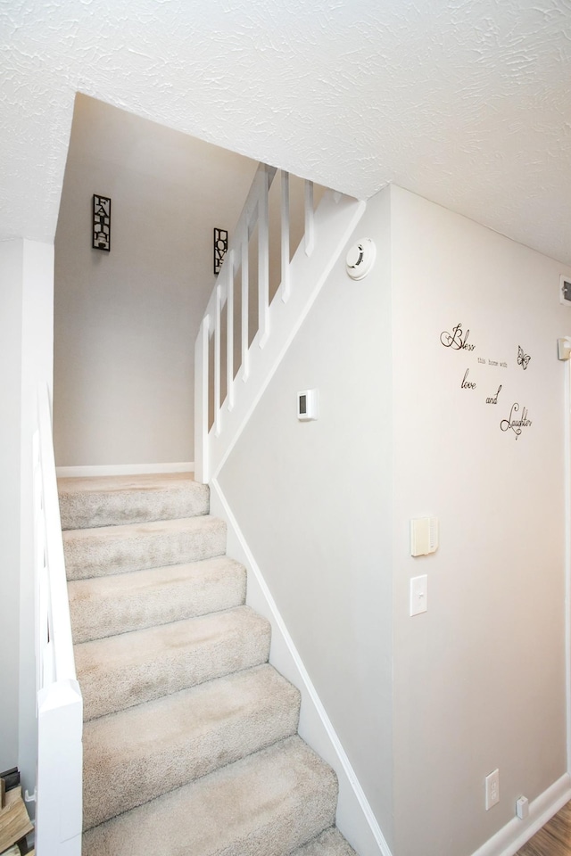 staircase with a textured ceiling