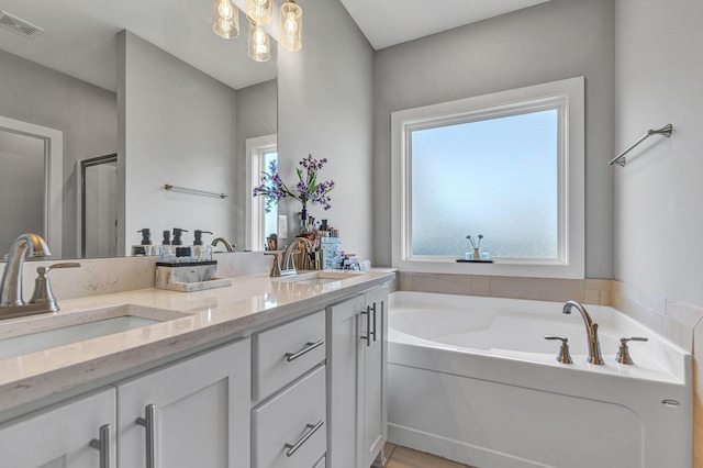 bathroom with vanity, a notable chandelier, and plus walk in shower