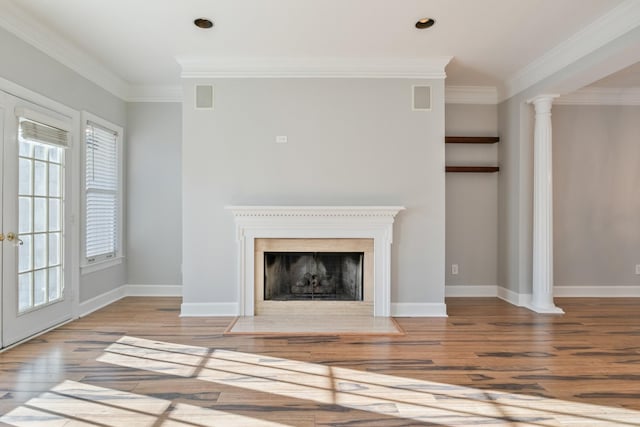 unfurnished living room with decorative columns, crown molding, and light hardwood / wood-style flooring