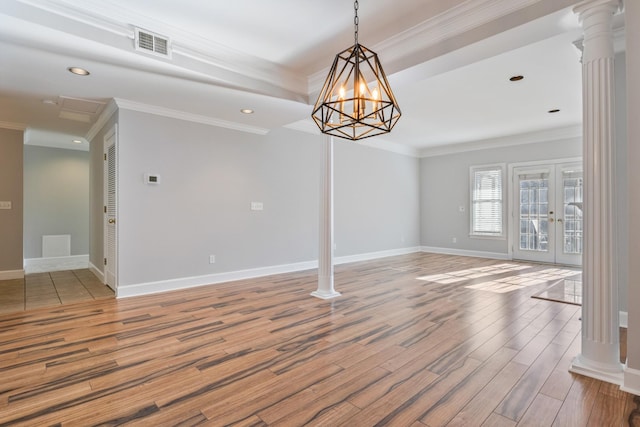 unfurnished room featuring decorative columns, crown molding, hardwood / wood-style flooring, and french doors