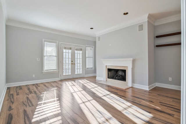 unfurnished living room with hardwood / wood-style floors, ornamental molding, and french doors