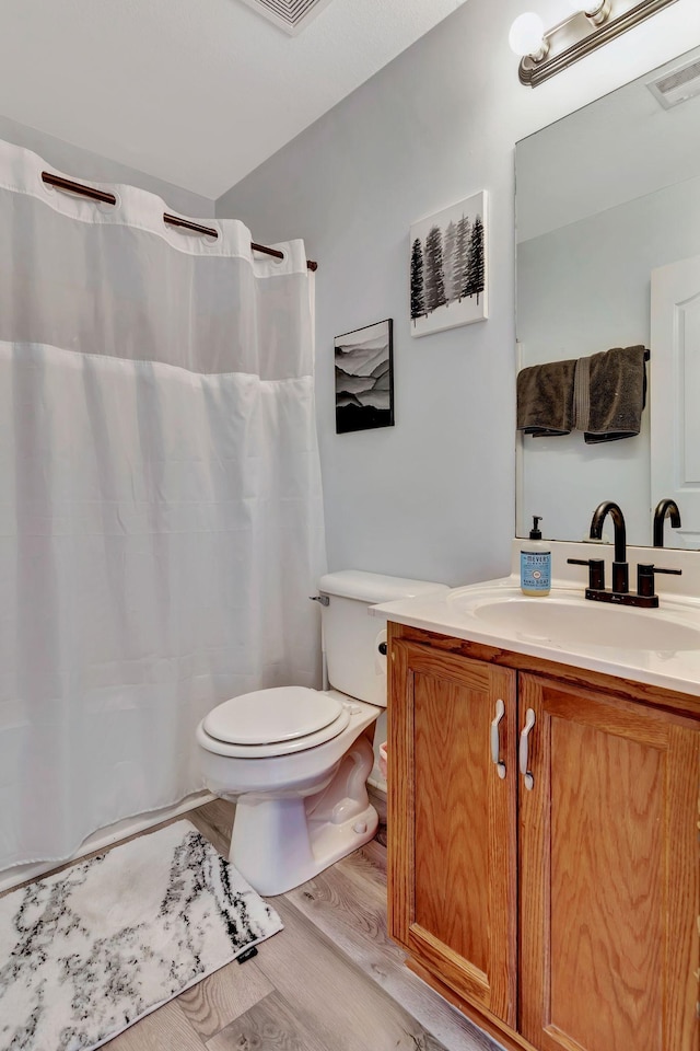 bathroom with vanity, toilet, and hardwood / wood-style floors