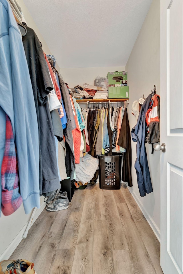 walk in closet with lofted ceiling and light wood-type flooring