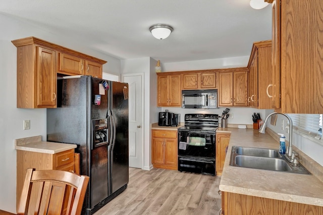 kitchen featuring light hardwood / wood-style floors, sink, and black appliances