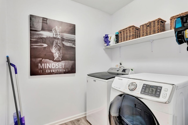 washroom featuring washing machine and clothes dryer and light hardwood / wood-style flooring