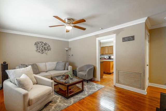 living room featuring wood-type flooring, ornamental molding, and ceiling fan