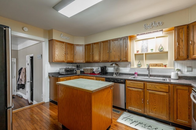 kitchen with dark wood-type flooring, sink, appliances with stainless steel finishes, a kitchen island, and backsplash