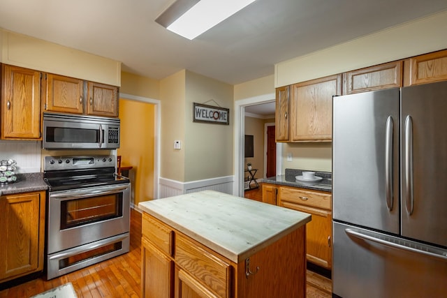 kitchen featuring appliances with stainless steel finishes, a center island, and light hardwood / wood-style flooring