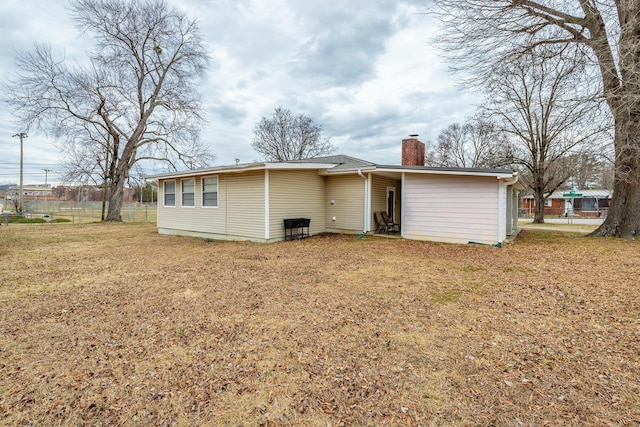 rear view of property featuring a lawn