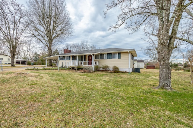 view of front of home featuring central AC, covered porch, and a front yard