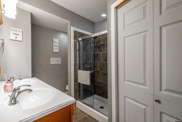 bathroom with vanity, tile patterned floors, toilet, and walk in shower