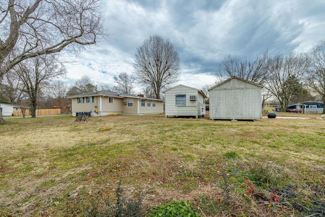 rear view of house featuring a storage shed and a lawn