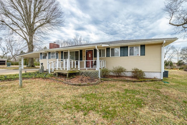 view of front of home with a carport, central AC, a front yard, and covered porch