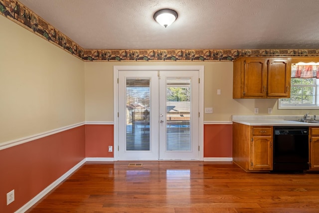 kitchen featuring a healthy amount of sunlight, hardwood / wood-style floors, french doors, and dishwasher