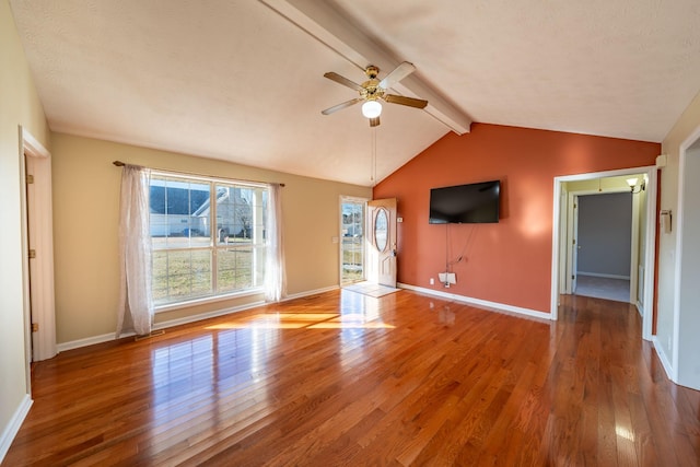 unfurnished living room with hardwood / wood-style flooring, ceiling fan, and lofted ceiling with beams