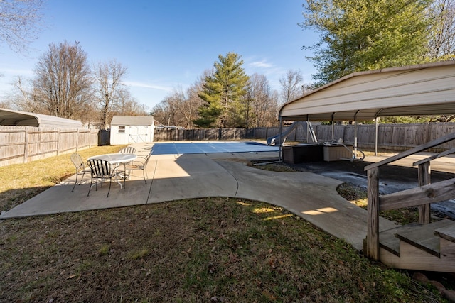 view of swimming pool with a storage shed and a patio area