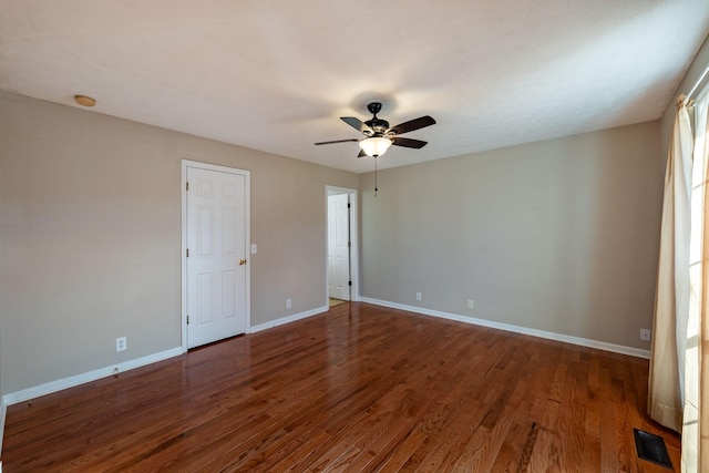 unfurnished room featuring dark wood-type flooring and ceiling fan