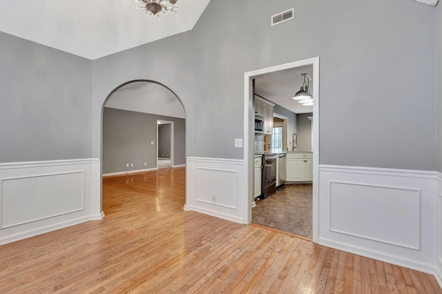 spare room with sink and light hardwood / wood-style floors