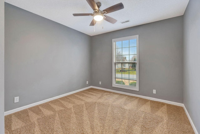 carpeted empty room with ceiling fan and a textured ceiling