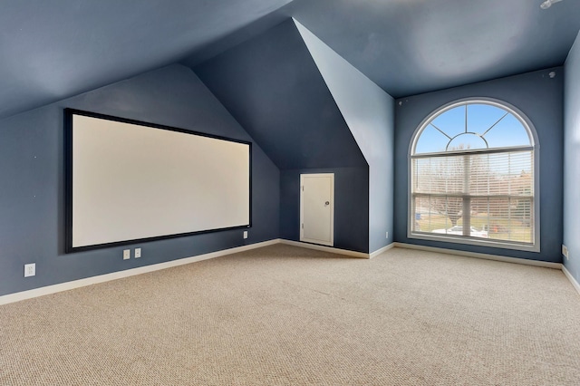 home theater with lofted ceiling and light carpet