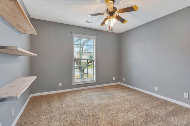 carpeted spare room featuring ceiling fan and a textured ceiling