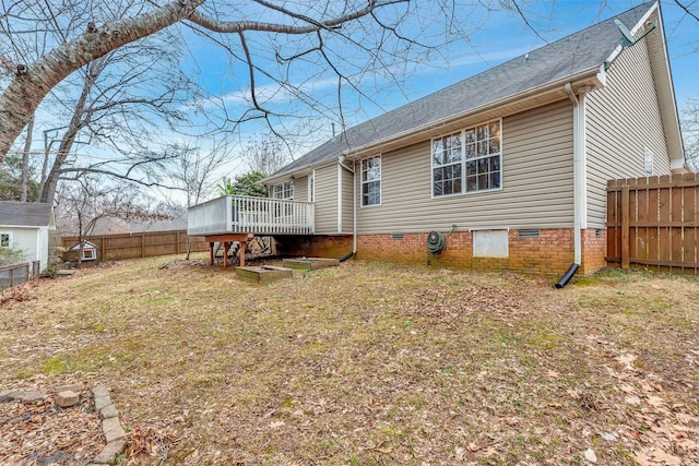 rear view of property with a wooden deck and a lawn