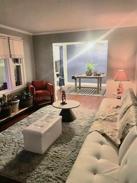 living room with hardwood / wood-style flooring and ornamental molding