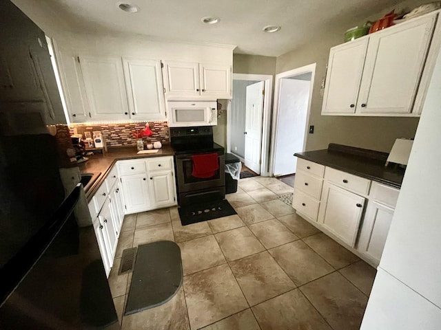 kitchen with electric stove, white cabinetry, decorative backsplash, and light tile patterned floors