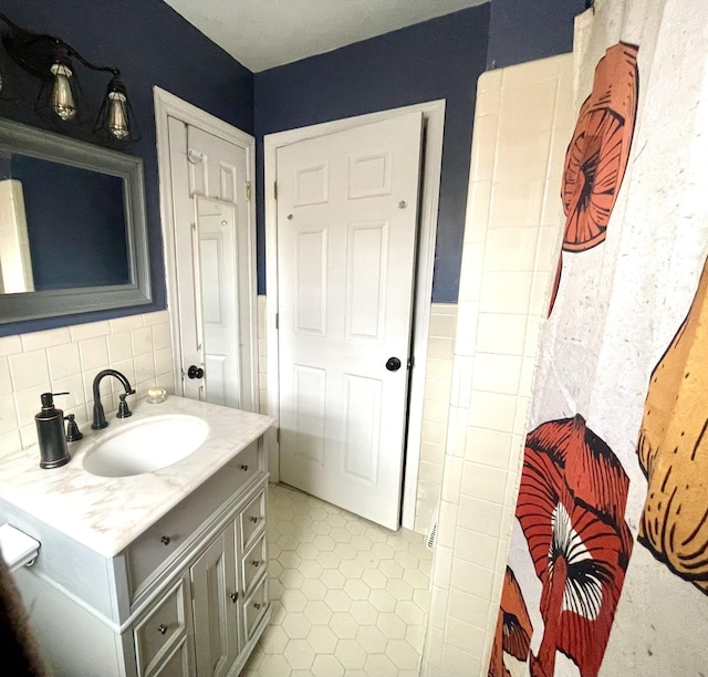 bathroom with vanity, tile patterned flooring, and tasteful backsplash