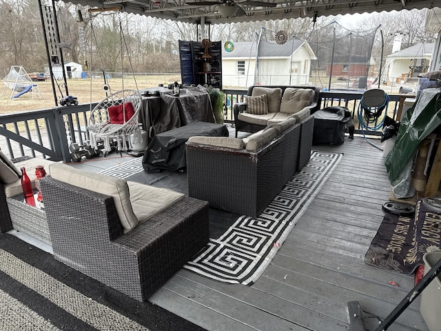 wooden terrace featuring an outdoor hangout area, a playground, and a trampoline