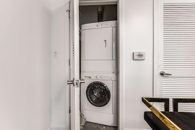 clothes washing area featuring stacked washer / dryer